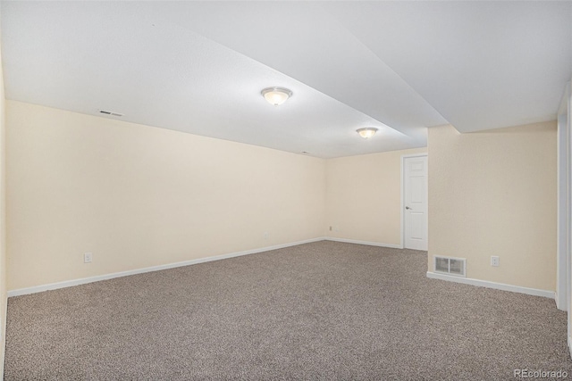 carpeted spare room featuring baseboards and visible vents