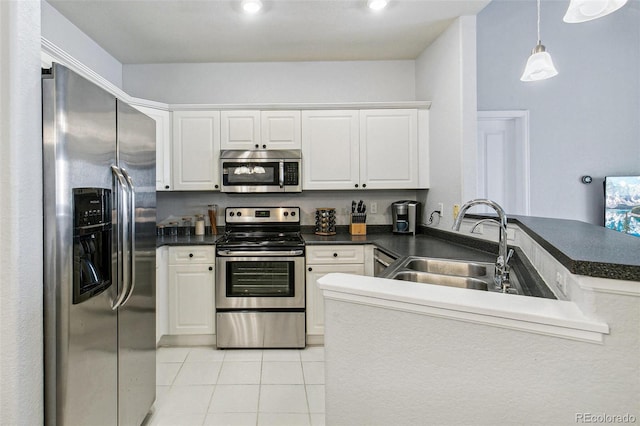 kitchen with stainless steel appliances, kitchen peninsula, and white cabinets