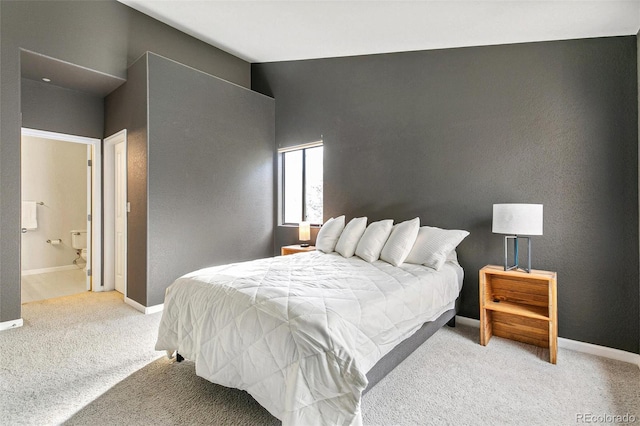 bedroom featuring light colored carpet and ensuite bath