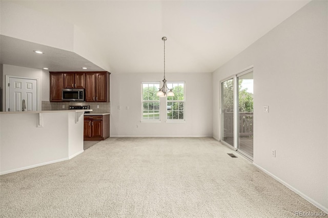 8267 S Sicily Ct, Aurora, CO 80016 - kitchen featuring stainless steel microwave, plenty of natural light, backsplash, recessed lighting, and light colored carpet