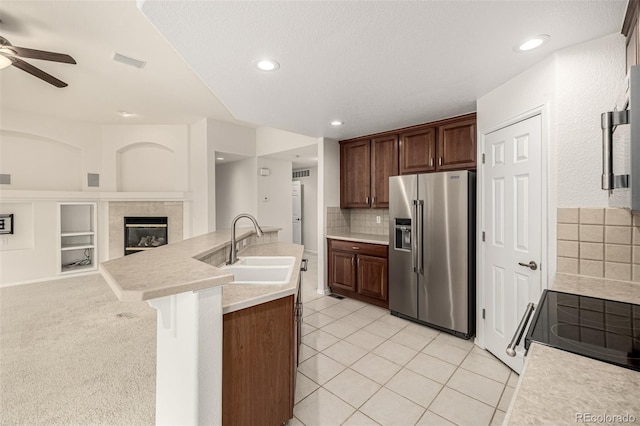 8267 S Sicily Ct, Aurora, CO 80016 - kitchen with high end fridge, a sink, a ceiling fan, light countertops, and a tiled fireplace