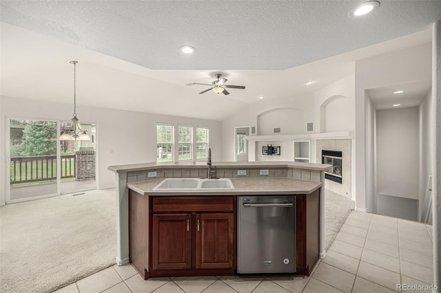 8267 S Sicily Ct, Aurora, CO 80016 - kitchen featuring stainless steel dishwasher, light carpet, a tile fireplace, a sink, and open floor plan