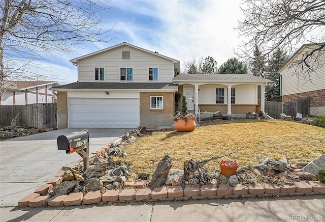 tri-level home with a front lawn, driveway, fence, an attached garage, and a shingled roof