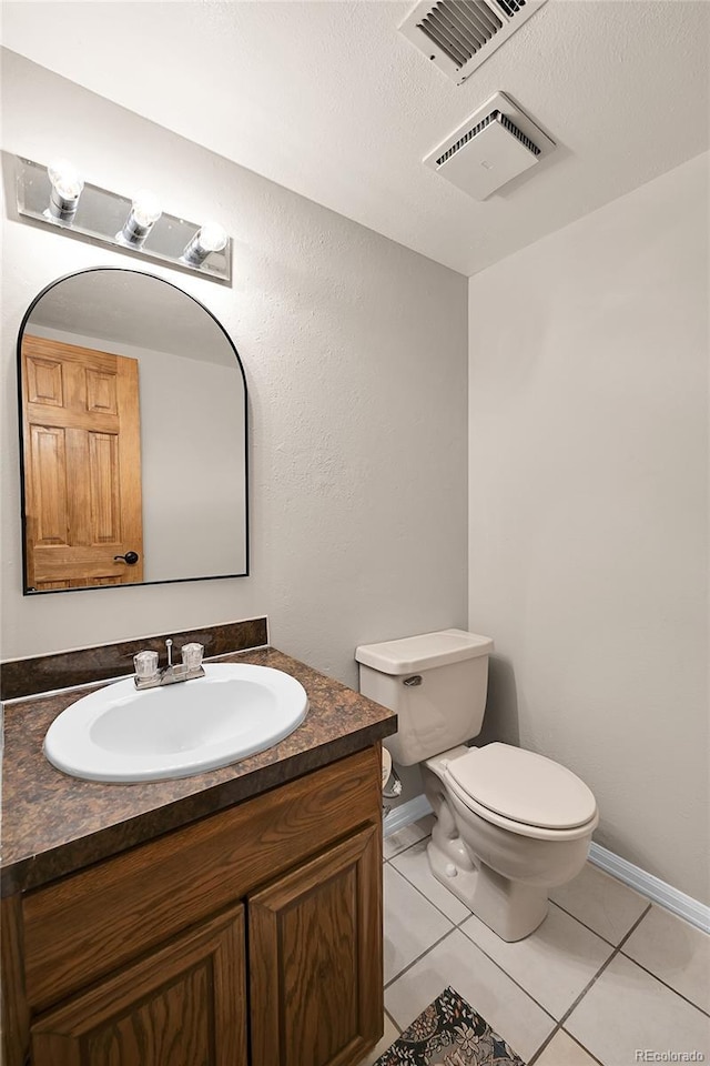 half bath featuring tile patterned floors, visible vents, toilet, and vanity