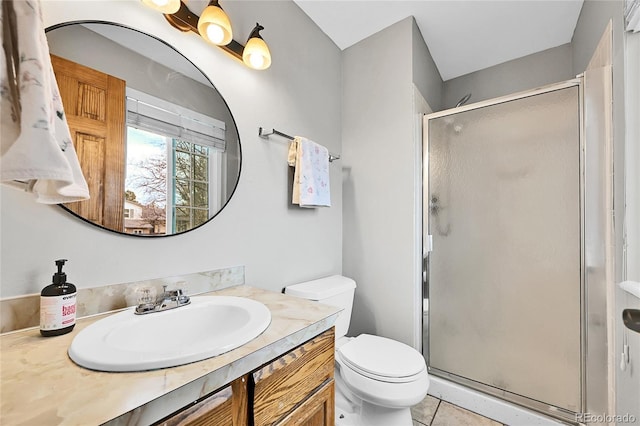 bathroom featuring toilet, a stall shower, vanity, and tile patterned flooring