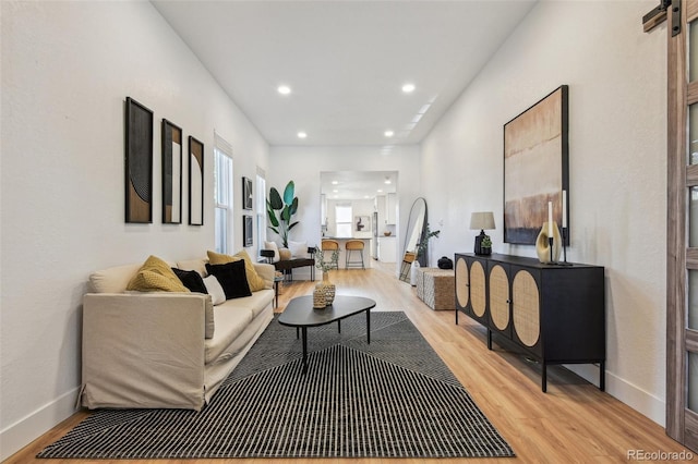 living room featuring light wood-style flooring, recessed lighting, and baseboards