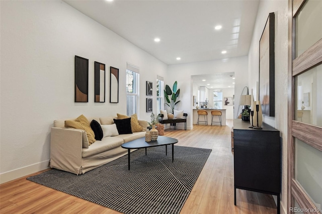 living room with recessed lighting, light wood-type flooring, and baseboards