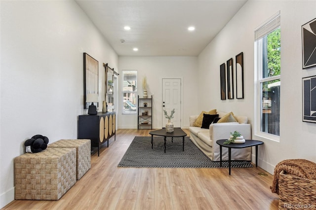 living area featuring light wood-type flooring, recessed lighting, and baseboards