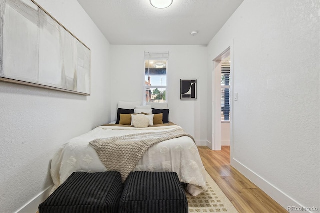 bedroom with light wood-style flooring and baseboards