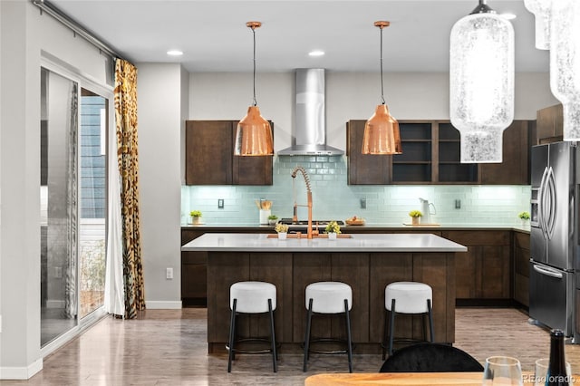 3384 Cranston Cir, Highlands Ranch, CO 80126 - kitchen with stainless steel fridge with ice dispenser, wall chimney exhaust hood, light countertops, and light wood-style floors
