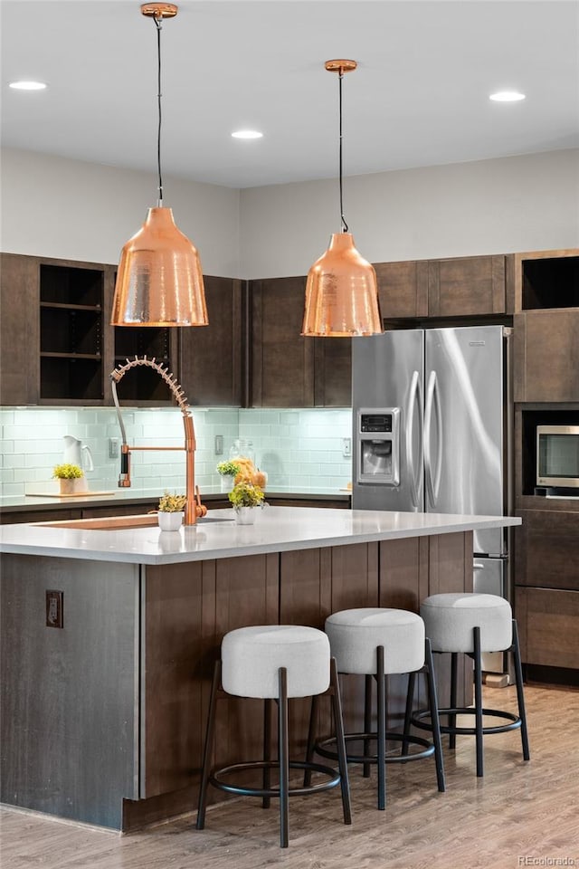 3384 Cranston Cir, Highlands Ranch, CO 80126 - kitchen with modern cabinets, light countertops, light wood-style floors, and a breakfast bar area