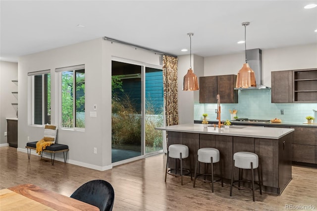 3384 Cranston Cir, Highlands Ranch, CO 80126 - kitchen featuring wall chimney range hood, open shelves, light wood-style flooring, light countertops, and recessed lighting