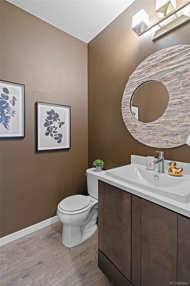 3384 Cranston Cir, Highlands Ranch, CO 80126 - half bathroom featuring wood finished floors, toilet, vanity, and baseboards