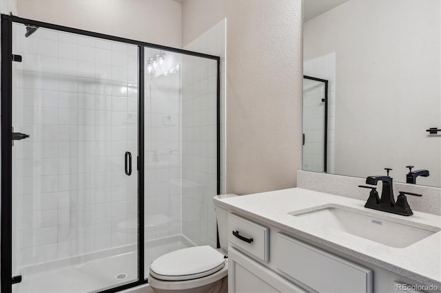 bathroom featuring vanity, toilet, and a shower with shower door