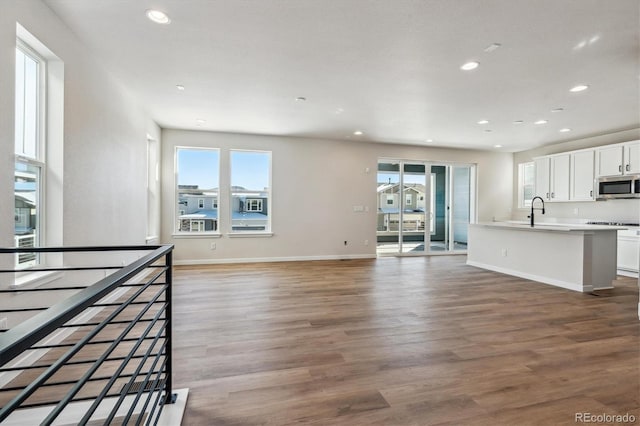 unfurnished living room with hardwood / wood-style flooring and sink