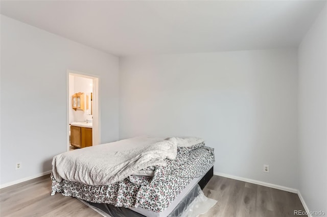 bedroom with wood-type flooring and ensuite bath