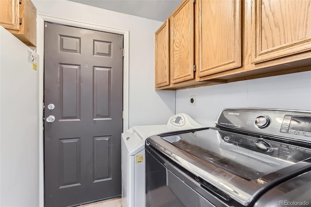 washroom with washing machine and dryer and cabinets