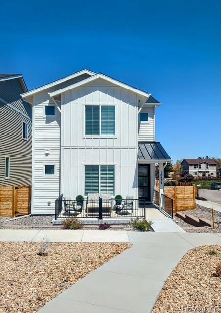 back of property with board and batten siding and fence