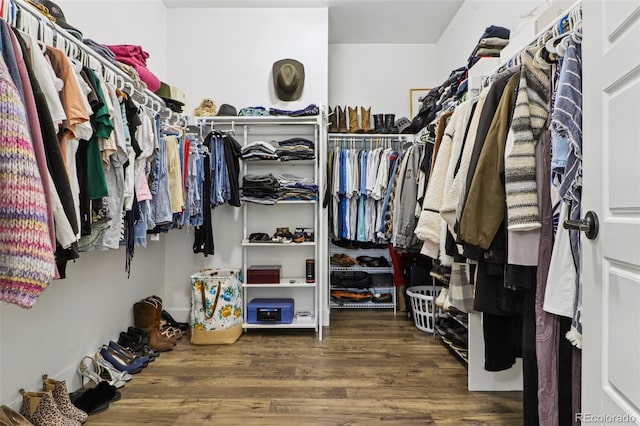 walk in closet with wood finished floors