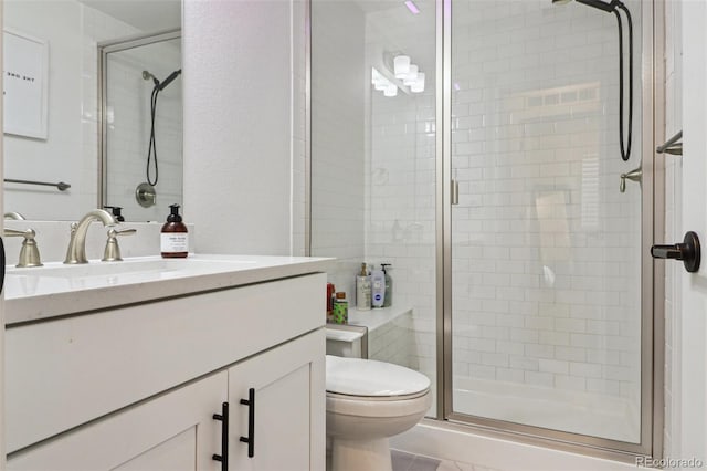 bathroom featuring a shower stall, toilet, and vanity