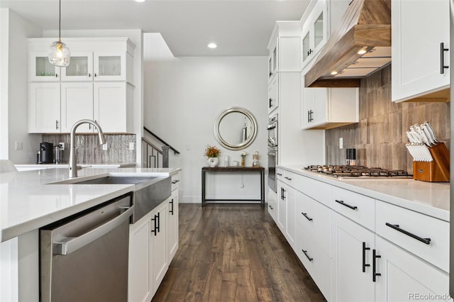 kitchen featuring a sink, stainless steel appliances, tasteful backsplash, and light countertops