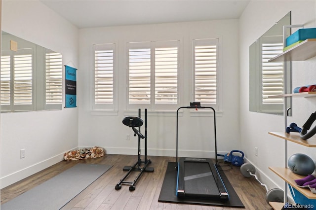 workout area with baseboards and wood finished floors