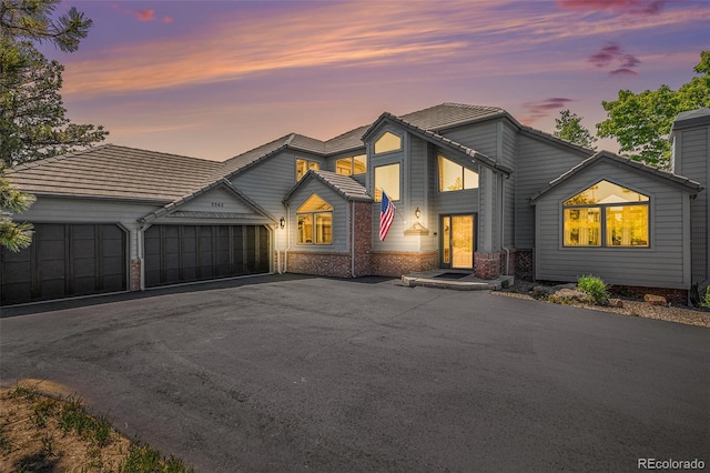 view of front of property with driveway, brick siding, and an attached garage