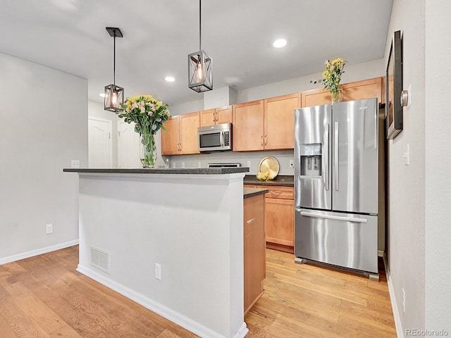 kitchen with light brown cabinets, decorative light fixtures, stainless steel appliances, and light hardwood / wood-style floors