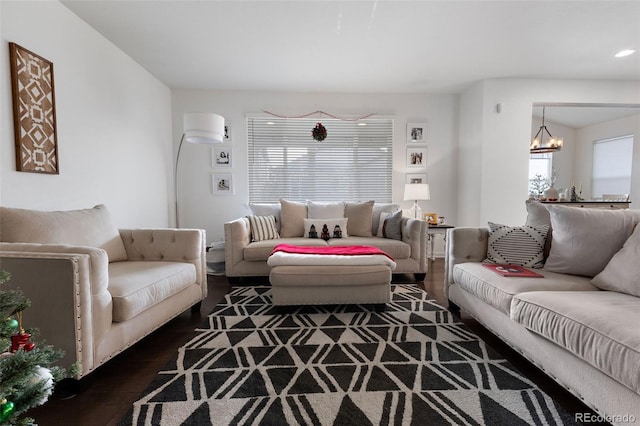 living room with dark hardwood / wood-style flooring and a notable chandelier