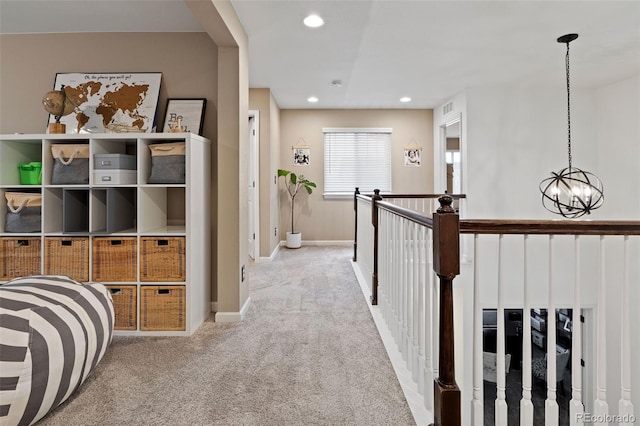 hall featuring a chandelier and light colored carpet