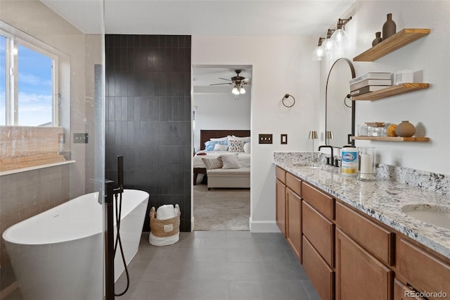 bathroom featuring vanity, ceiling fan, tile walls, tile patterned flooring, and a bathing tub