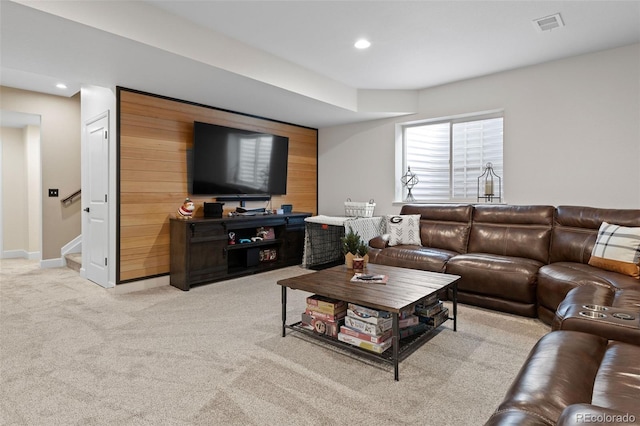 living room featuring light carpet and wood walls