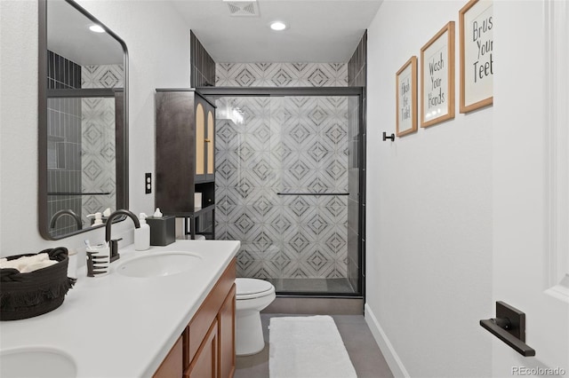 bathroom featuring vanity, toilet, and a shower with door