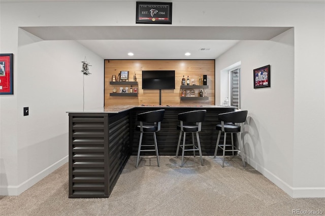 bar featuring carpet flooring and wooden walls