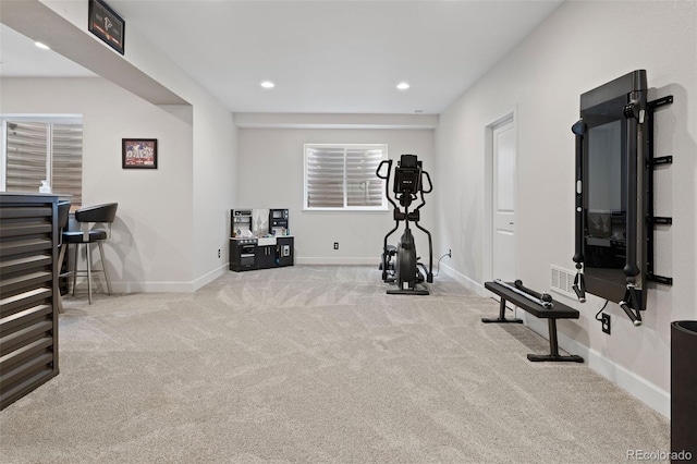 workout room featuring light carpet