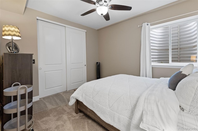 carpeted bedroom featuring ceiling fan and a closet