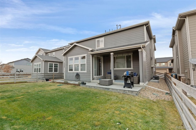 back of property with a yard and a patio