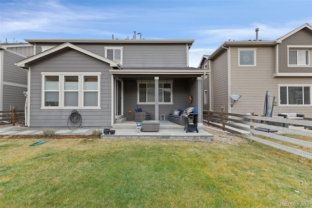 back of house featuring a lawn, a patio, and an outdoor hangout area