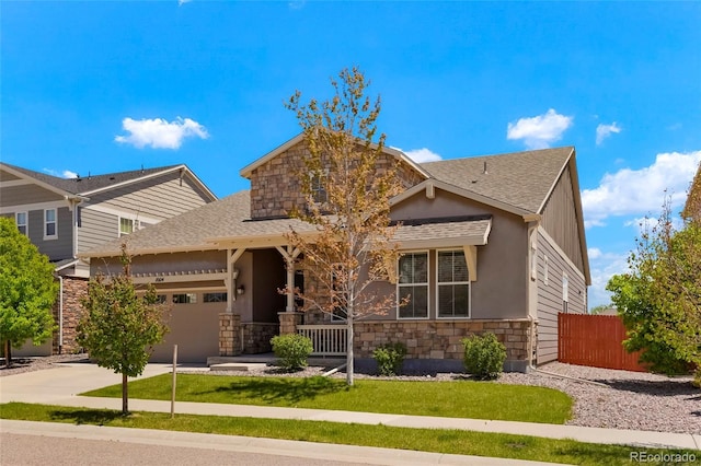 craftsman-style home featuring stone siding, fence, driveway, and an attached garage