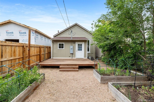 2841 Stout St, Denver, CO 80205 - rear view of house with a vegetable garden, a fenced backyard, and a deck