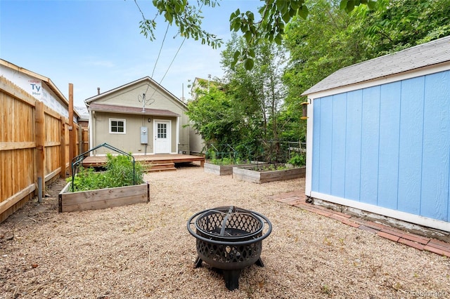 2841 Stout St, Denver, CO 80205 - back of house featuring a vegetable garden, an outbuilding, a fenced backyard, and a fire pit