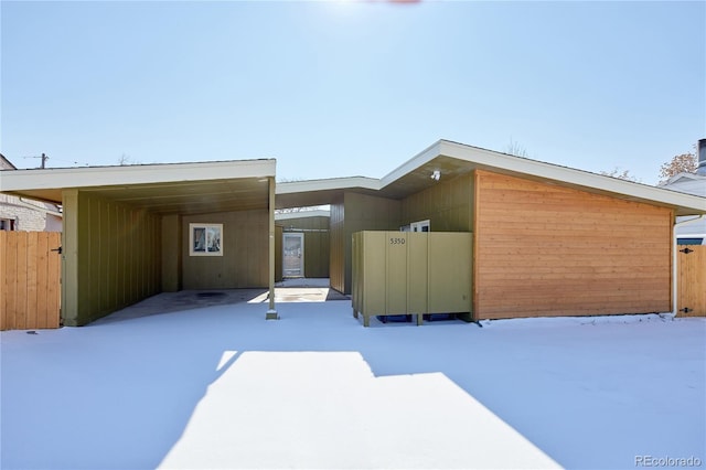 contemporary home featuring a carport and fence