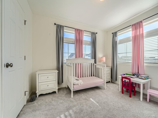 carpeted bedroom featuring a crib