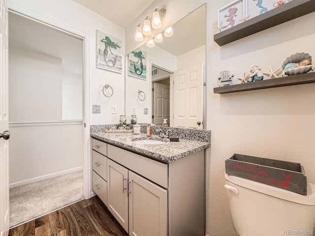 bathroom featuring hardwood / wood-style flooring, vanity, and toilet