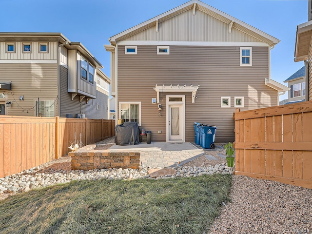 back of house with a patio area and a lawn