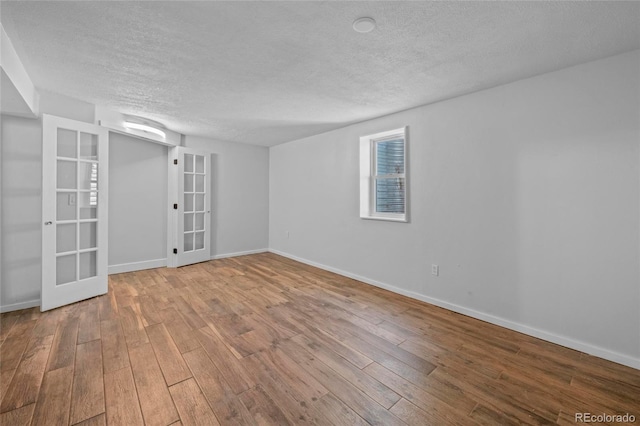 8580 Wiley Cir, Westminster, CO 80031 - spare room featuring french doors, a textured ceiling, and hardwood / wood-style flooring