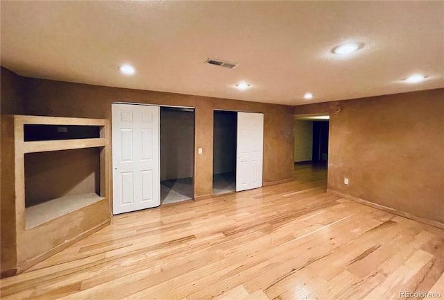 interior space featuring visible vents, two closets, light wood-style flooring, and recessed lighting