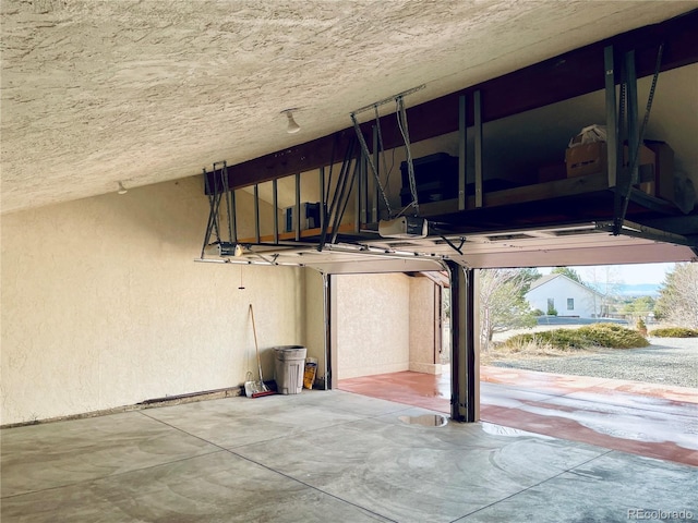 garage featuring a garage door opener and a textured wall