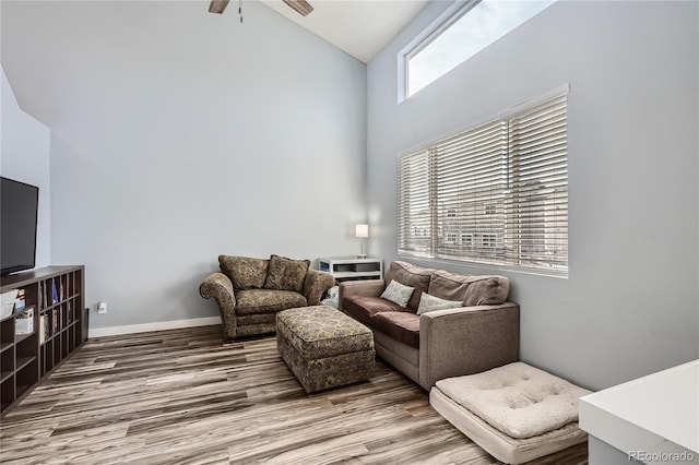 living room featuring ceiling fan, wood-type flooring, and high vaulted ceiling