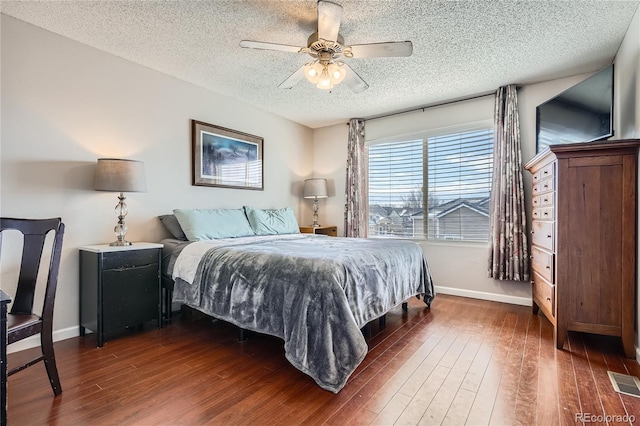 bedroom with a textured ceiling, ceiling fan, and dark wood-type flooring